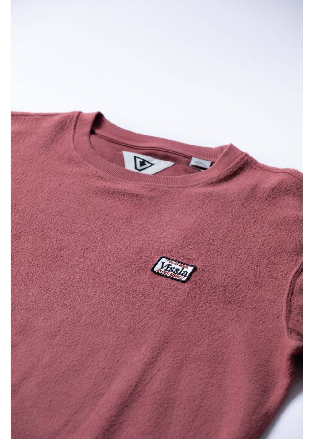 Close-up of Vissla Solid Sets Eco Crew sweatshirt logo in salsa red.
